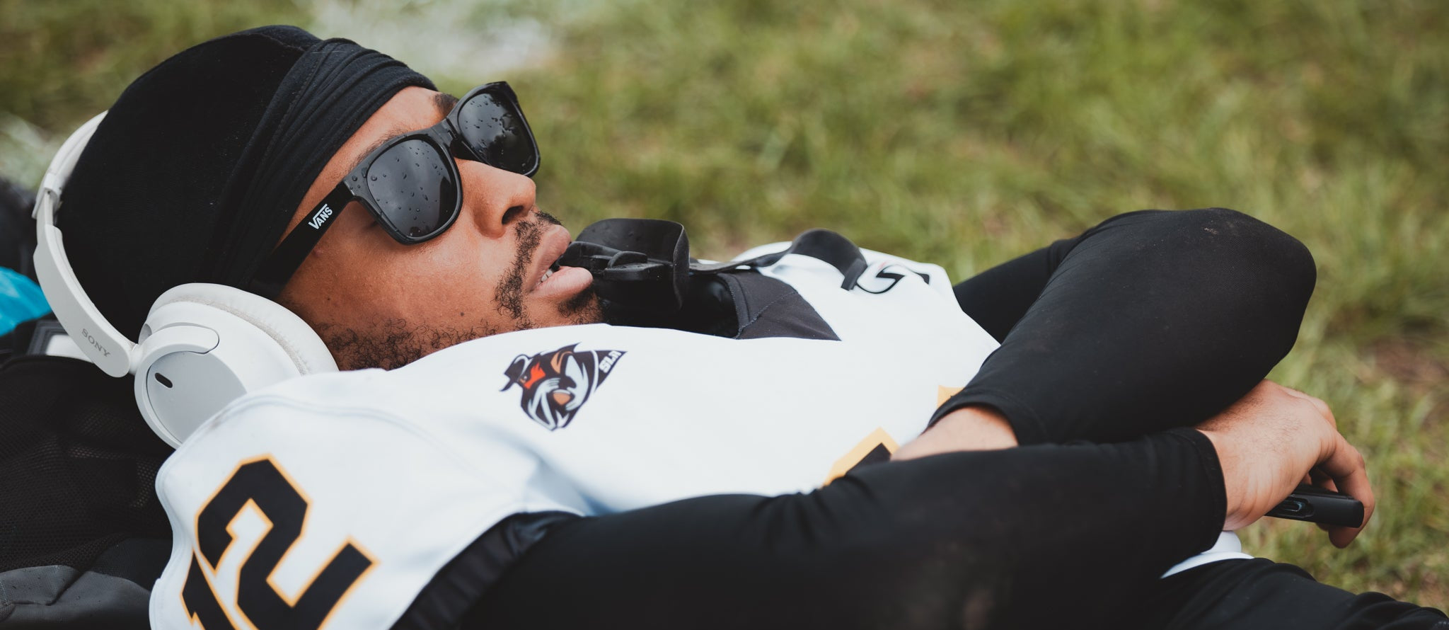 Person wearing a sports jersey and helmet on a grassy field